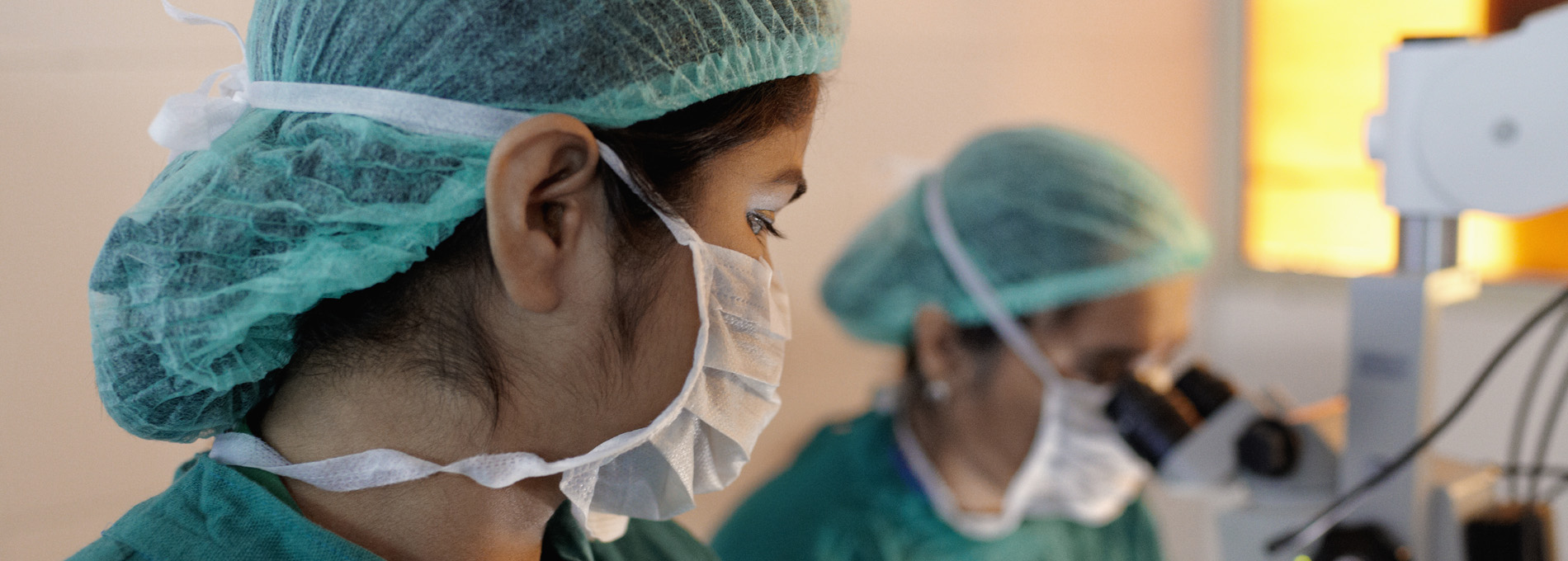 Surgeons wearing masks in hairnets.