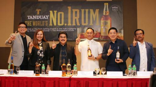 People at a table celebrating. Holding up a number 1 finger.