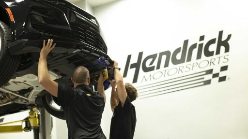 Hendrick Pros working on brakes of car.