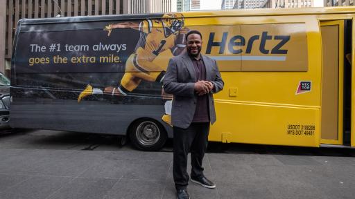 Jerome &ldquo;The Bus&rdquo; Bettis appears with the decked-out Hertz bus that will shuttle Hertz Gold Reward members to and from the Big Game.