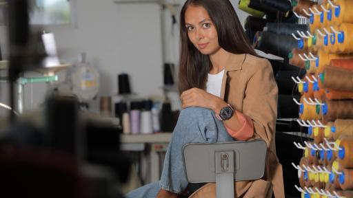 Woman wearing a watch and sitting in a chair with her knee up