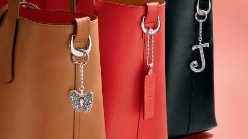 Three handbags with accessories on their handle.