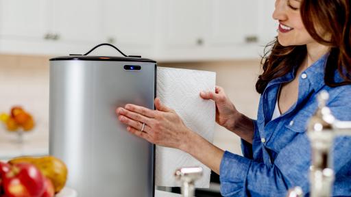 A woman using the Innovia Paper Towel Dispenser