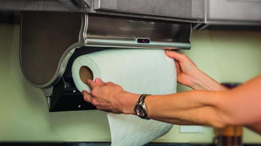A person loading the Innovia Paper Towel Dispenser