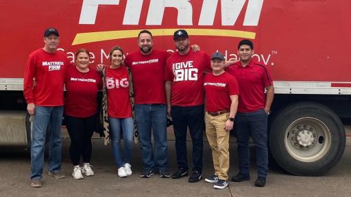Volunteers in front of a Mattress Firm sign