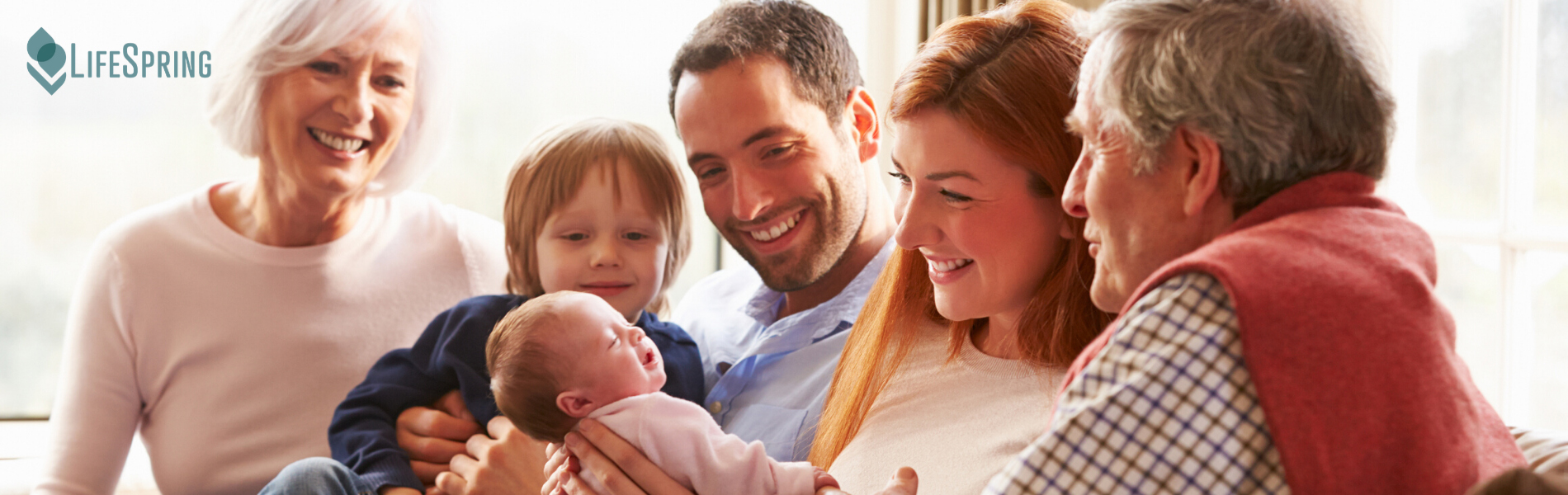 Family smiling and holding a baby