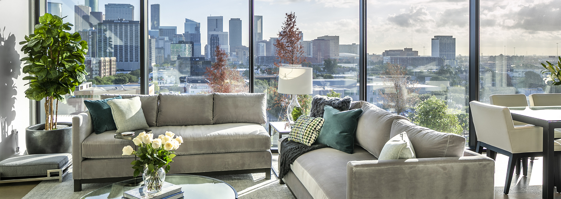 A luxurious apartment living room with a glass wall overlooking a cityscape.