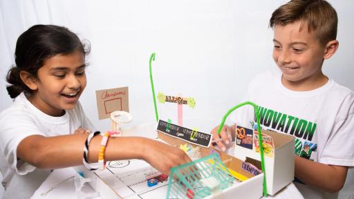 Two children play with a miniature home made sports complex.