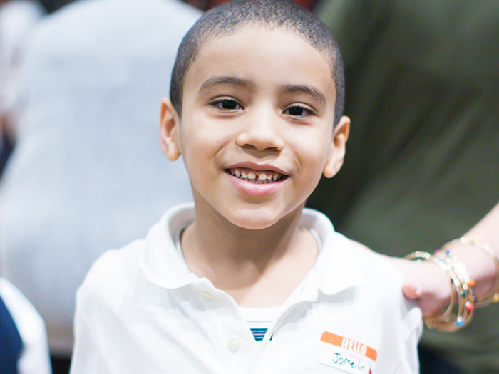 Kid with a card that says thank you for the shoes