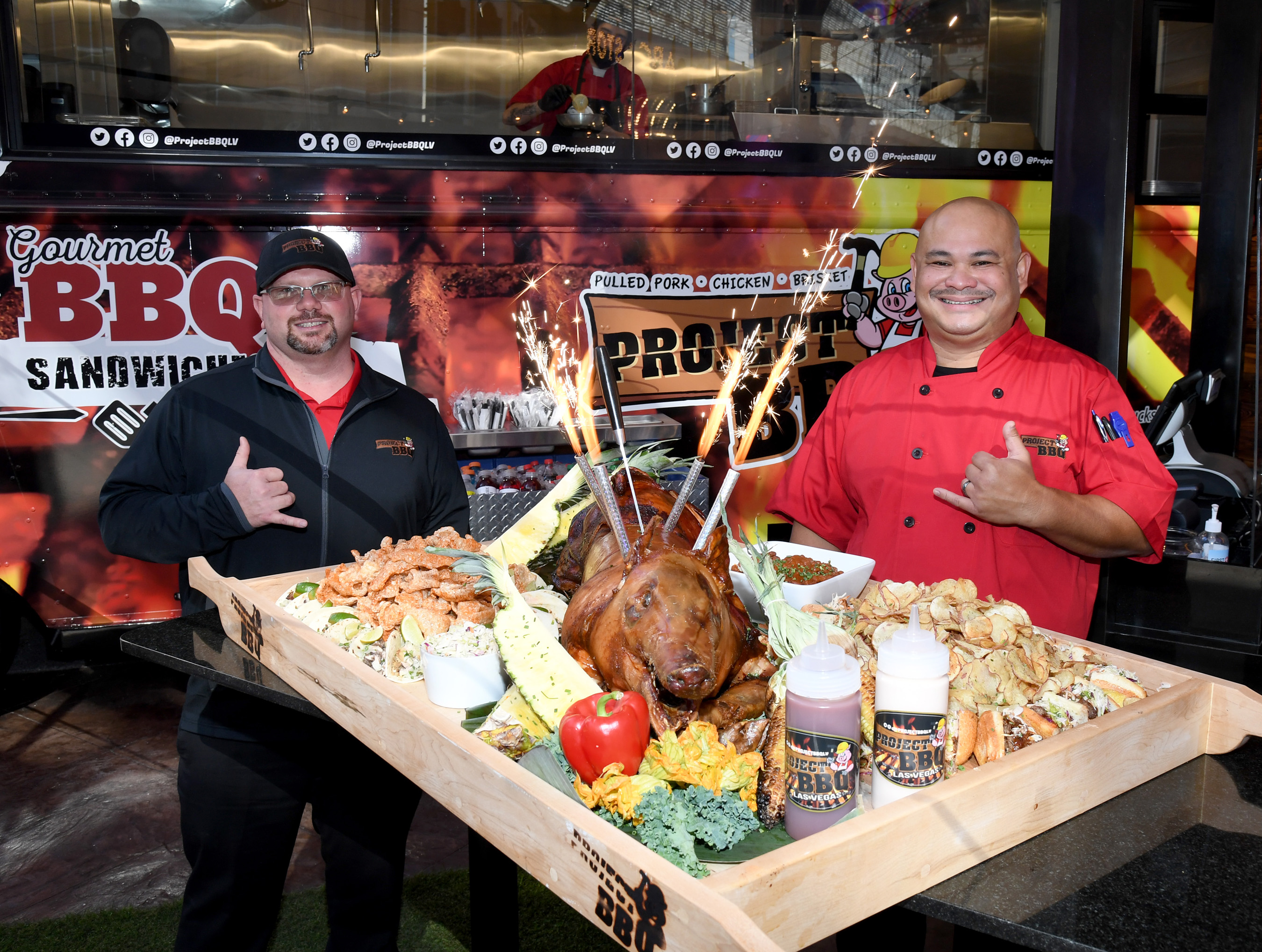 Rob baker and Chef Rex posing with a roasted pig