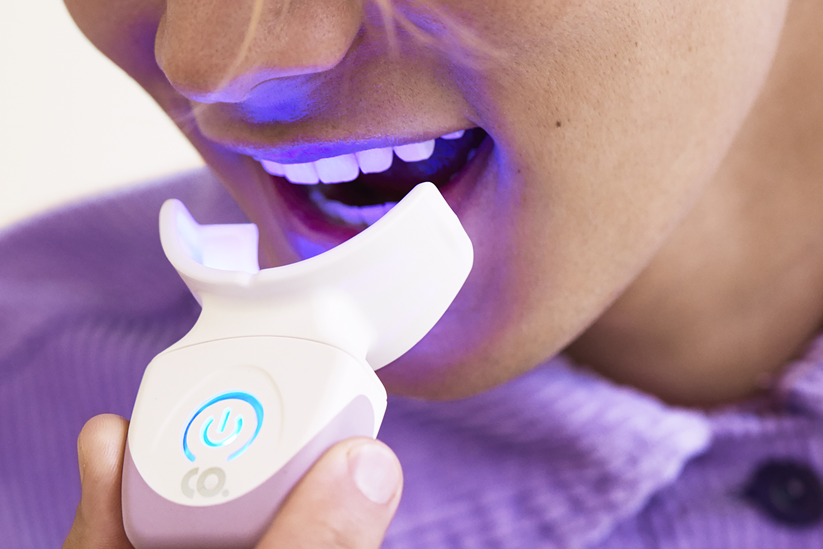 Person using a Colgate Whitening device