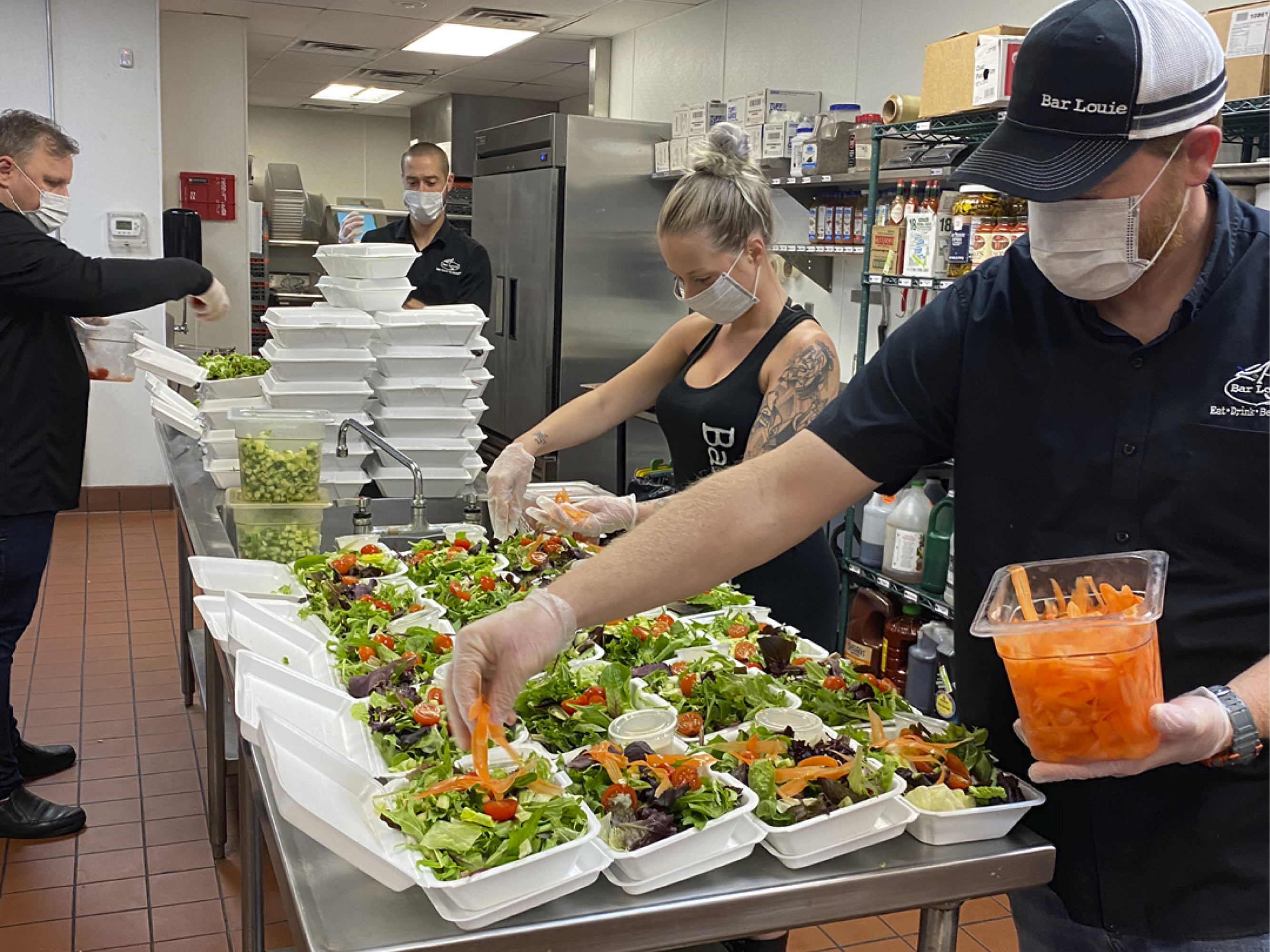 Bar Louie team members preparing meals to deliver to local front-line workers in the midst of COVID-19.