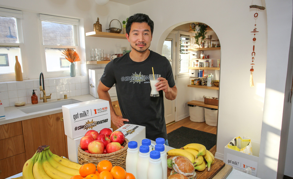 Holding a glass of milk in the kitchen