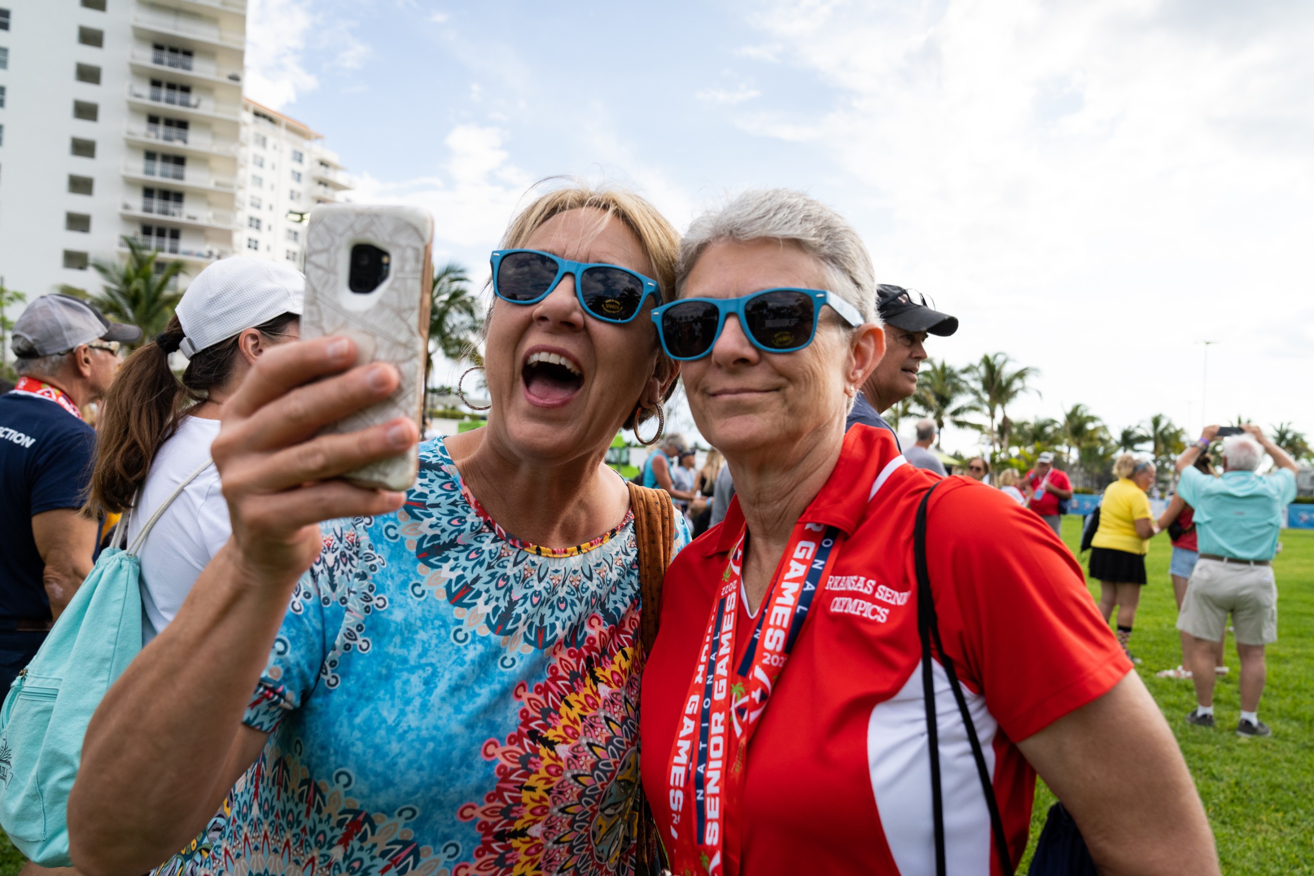 Participants stay shady in complimentary iovera° sunglasses during the outdoor event to attempt to break the GUINNESS WORLD RECORDS™ title for the Largest Game of Freeze Dance, at Las Olas Intracoastal Promenade Park in Fort Lauderdale, Florida, during the 2022 National Senior Games