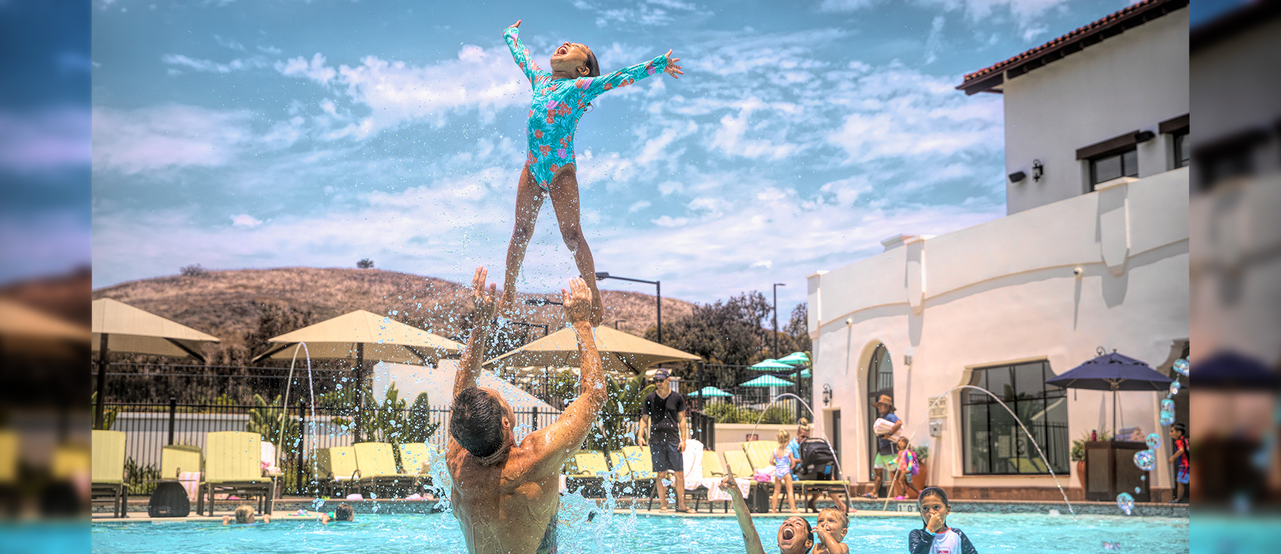 Father playing with daughter in pool