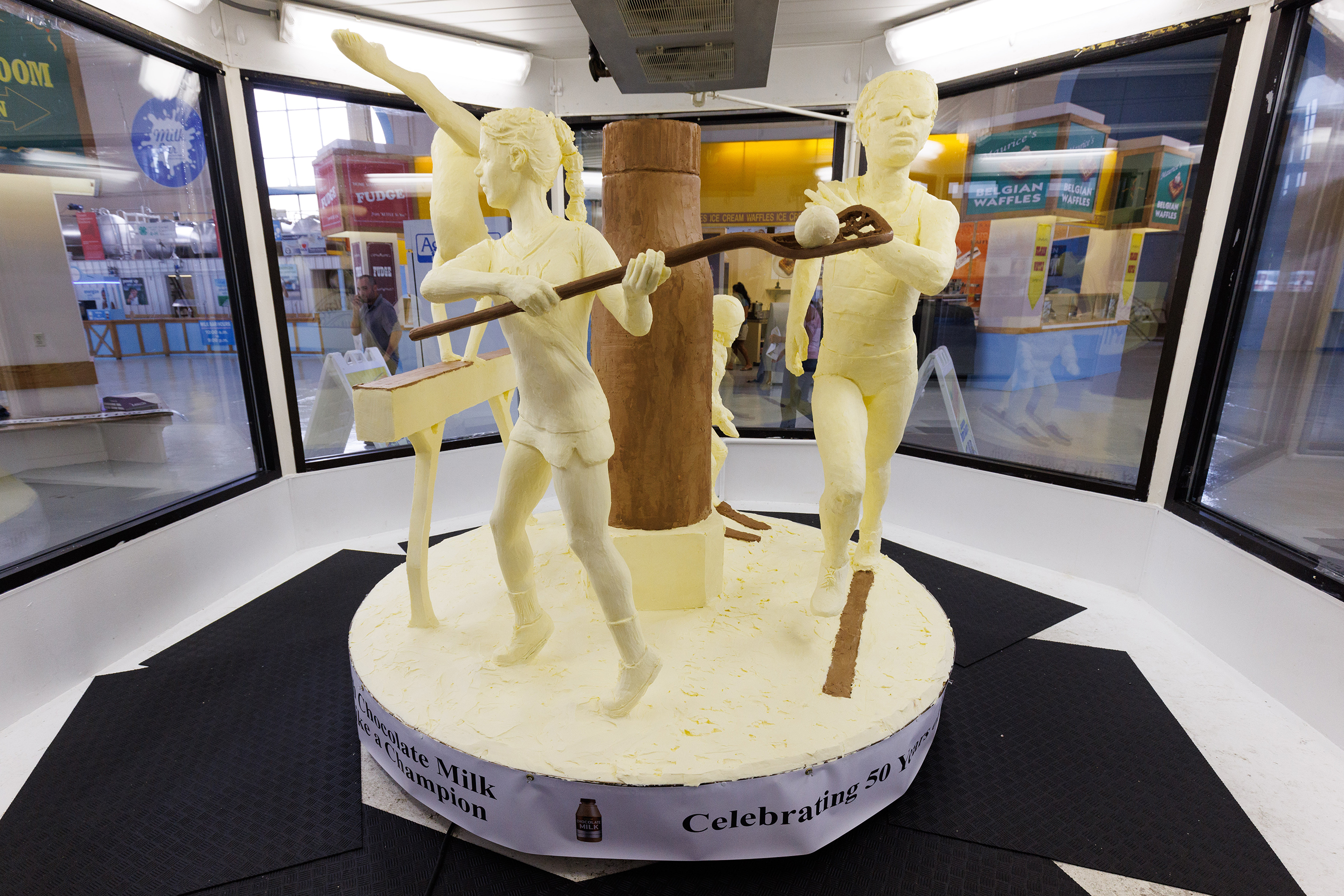 American Dairy Association North East unveiled the 54th Annual Butter Sculpture at the New York State Fair on August 23, 2022, titled Refuel Her Greatness – Celebrating the 50th Anniversary of Title IX. The sculpture spotlights female athletes and how today’s athletes refuel with chocolate milk and features a progression of female athletes ranging in age from a child skier to a high school-aged gymnast to a college lacrosse player to an adult runner.