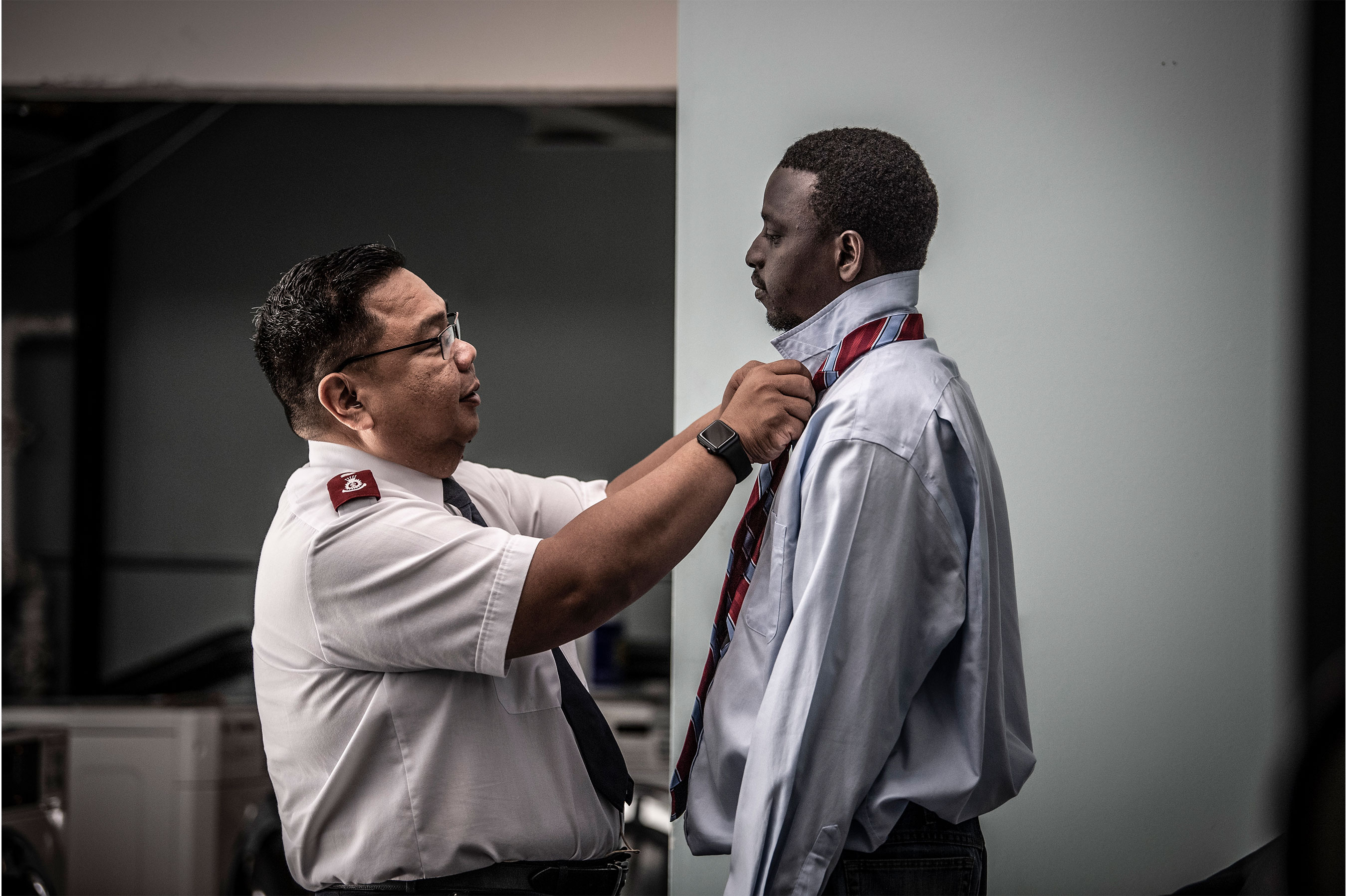 Man helping another man with a tie
