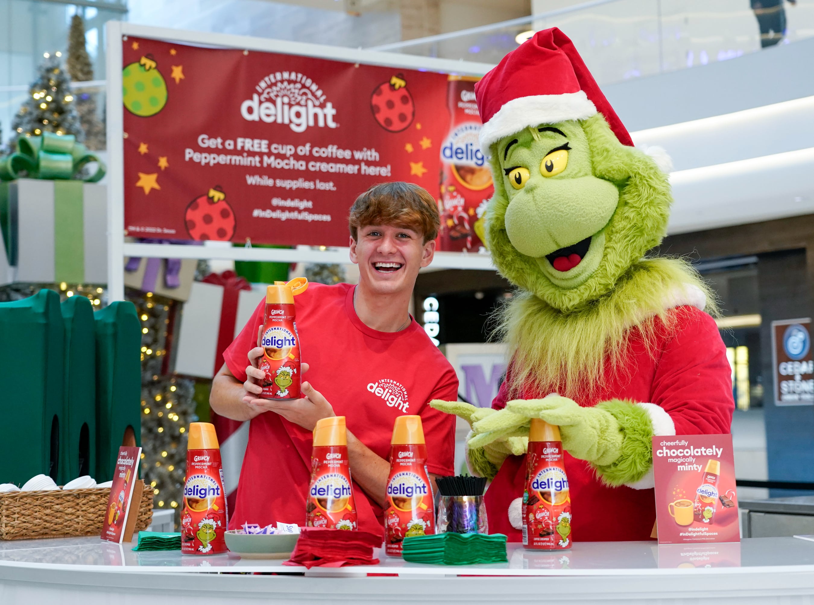The Grinch and TikTok star, Carter Kench, serve up coffee with International Delight Grinch Peppermint Mocha creamer at Mall of America on Thursday, Dec. 8, 2022, in Minneapolis.