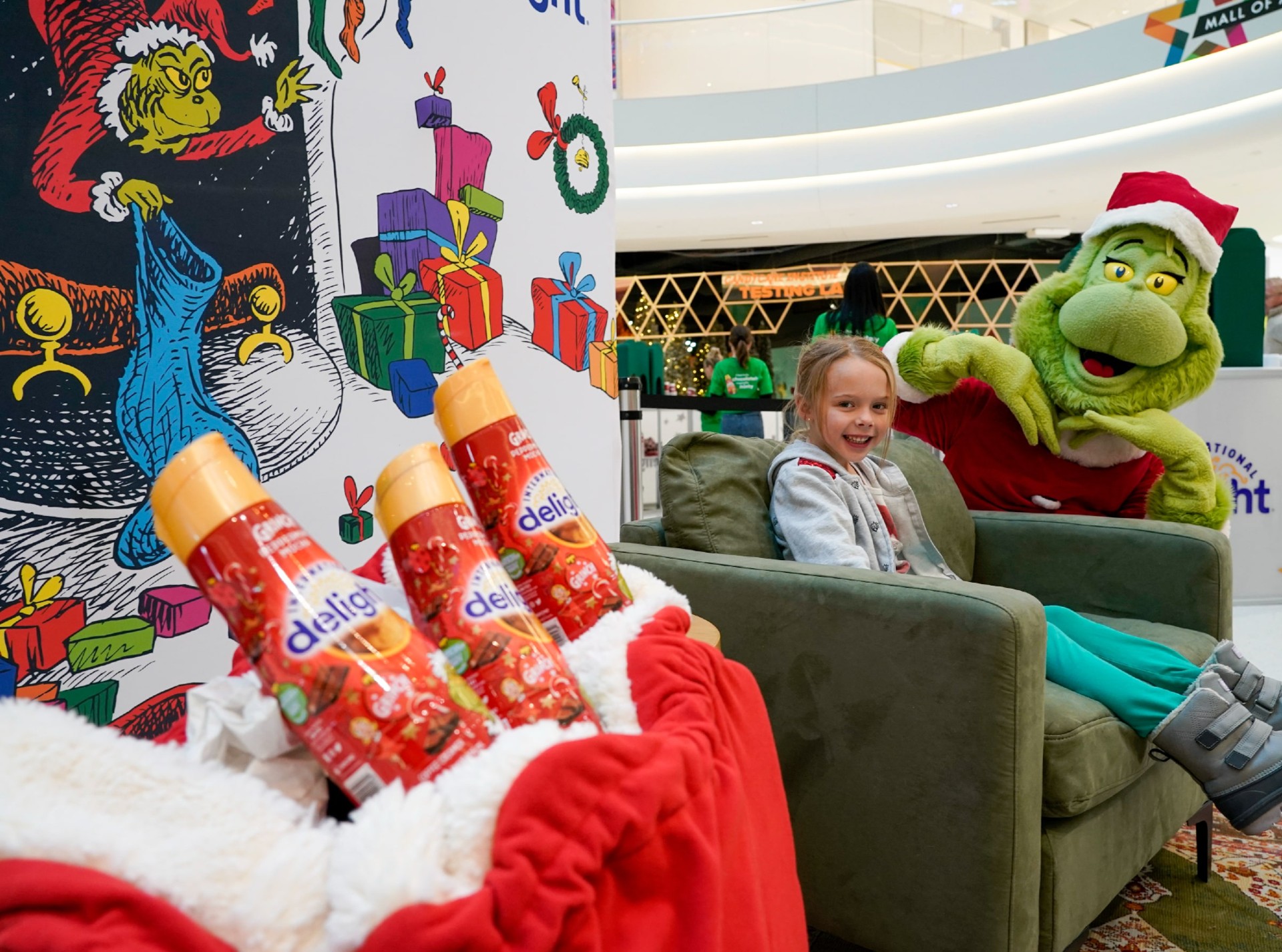 Paisley Blessing, 6, poses with the Grinch, who was at Mall of America on Thursday, Dec. 8, 2022, serving up free coffee with International Delight Grinch Peppermint Mocha creamer.