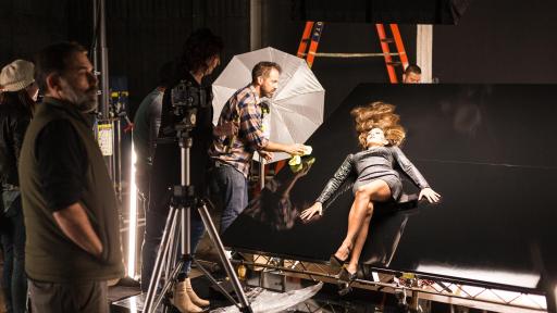 Modelo acostado sobre una superficie negra brillante con el pelo largo rubio.