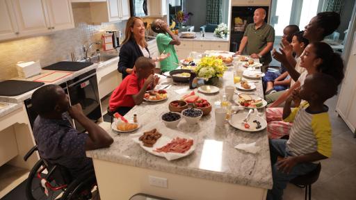 lots of people sitting in kitchen having dinner
