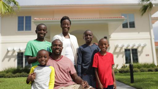 Family of 6 standing outside of their home
