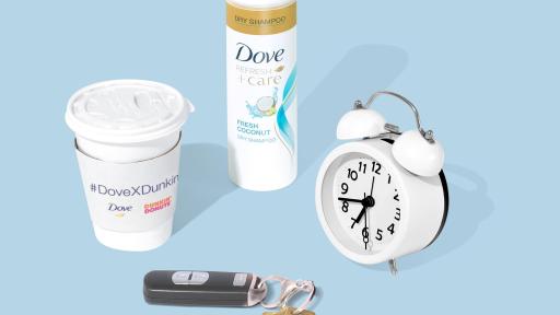 A cup of coffee, keys, an alarm and Dove Dry Shampoo on a powder blue background.
