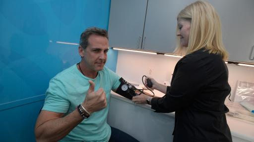 Carlos en la consulta de los doctores con una enfermera tomando su presión sanguínea.
