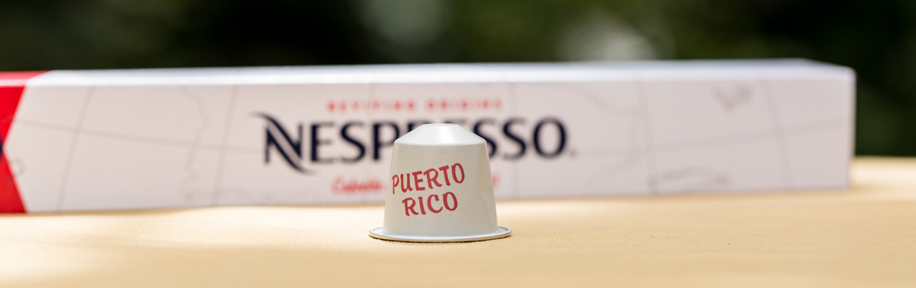 George Clooney and friend, holding a glass of Nespresso.