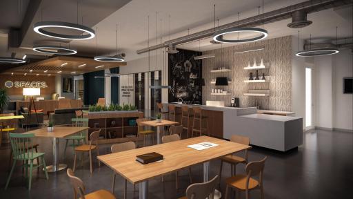 A spacious café with halo lights hung from the ceiling. There are many wooden tables and chairs.