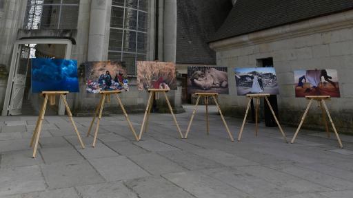 Exhibit of photos on canvas displays atop a castle balcony.