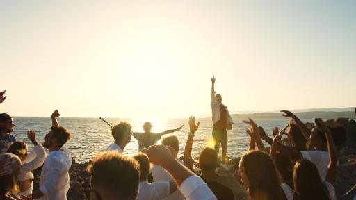Image of friend's of Alexis and Keith dancing to their song on a beach whilst wearing masks