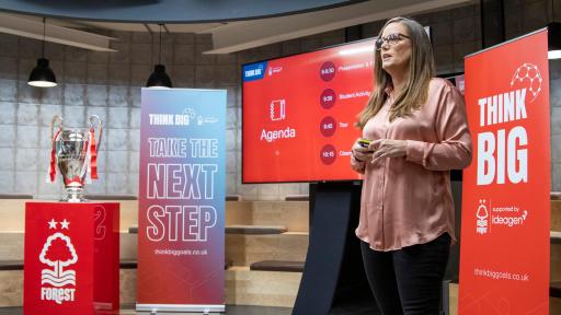 claire knee talking with signage