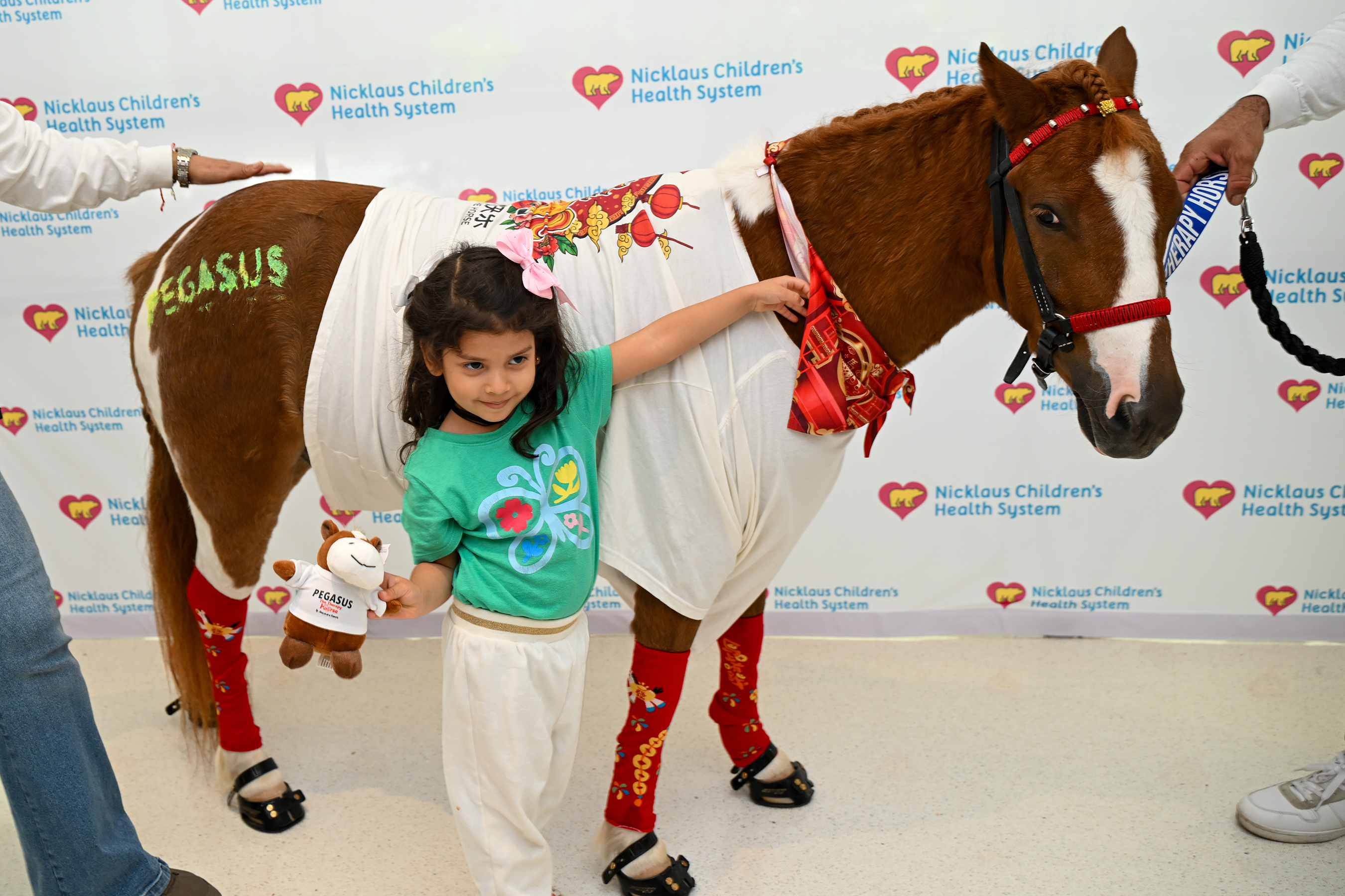 Nicklaus Children's Hospital patient meets pet therapy horse, Pegasus, in celebration of Lunar New Year and the Year of the Horse at the grand opening of Nicklaus Children's Panda Cares Center of Hope.