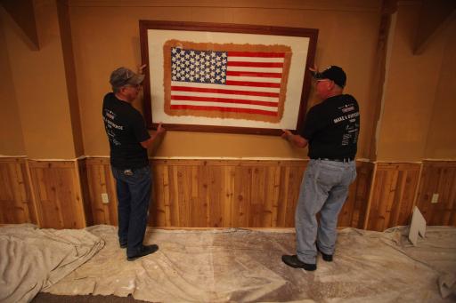 Volunteers rehang the centerpiece American flag