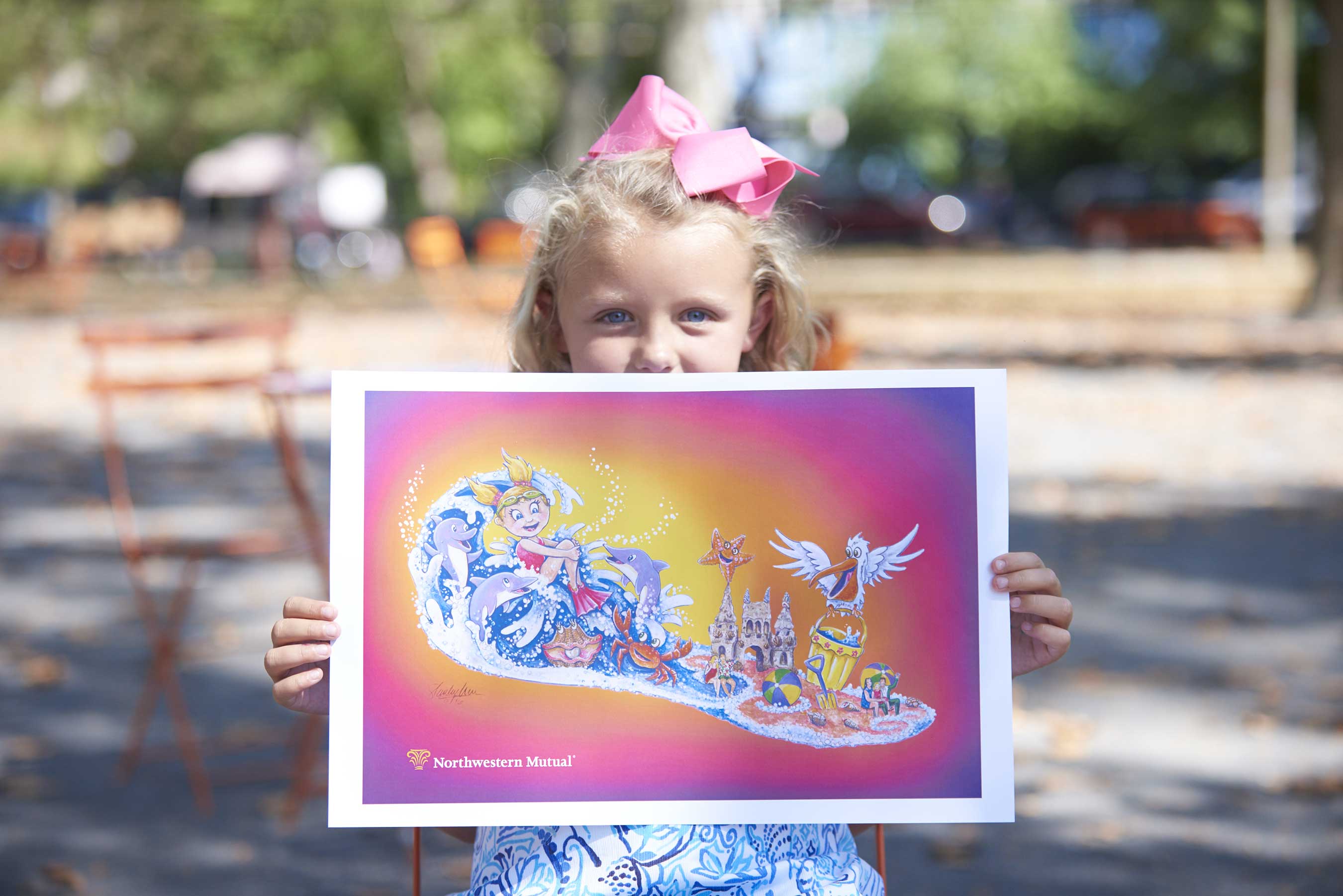 Edie Gilger, 7, displays the rendering of “Waves of Hope,” Northwestern Mutual’s float in the 2017 Rose Parade®. The design was inspired by Edie’s cancer fight and she will ride the float alongside her parents, oncologist and others.