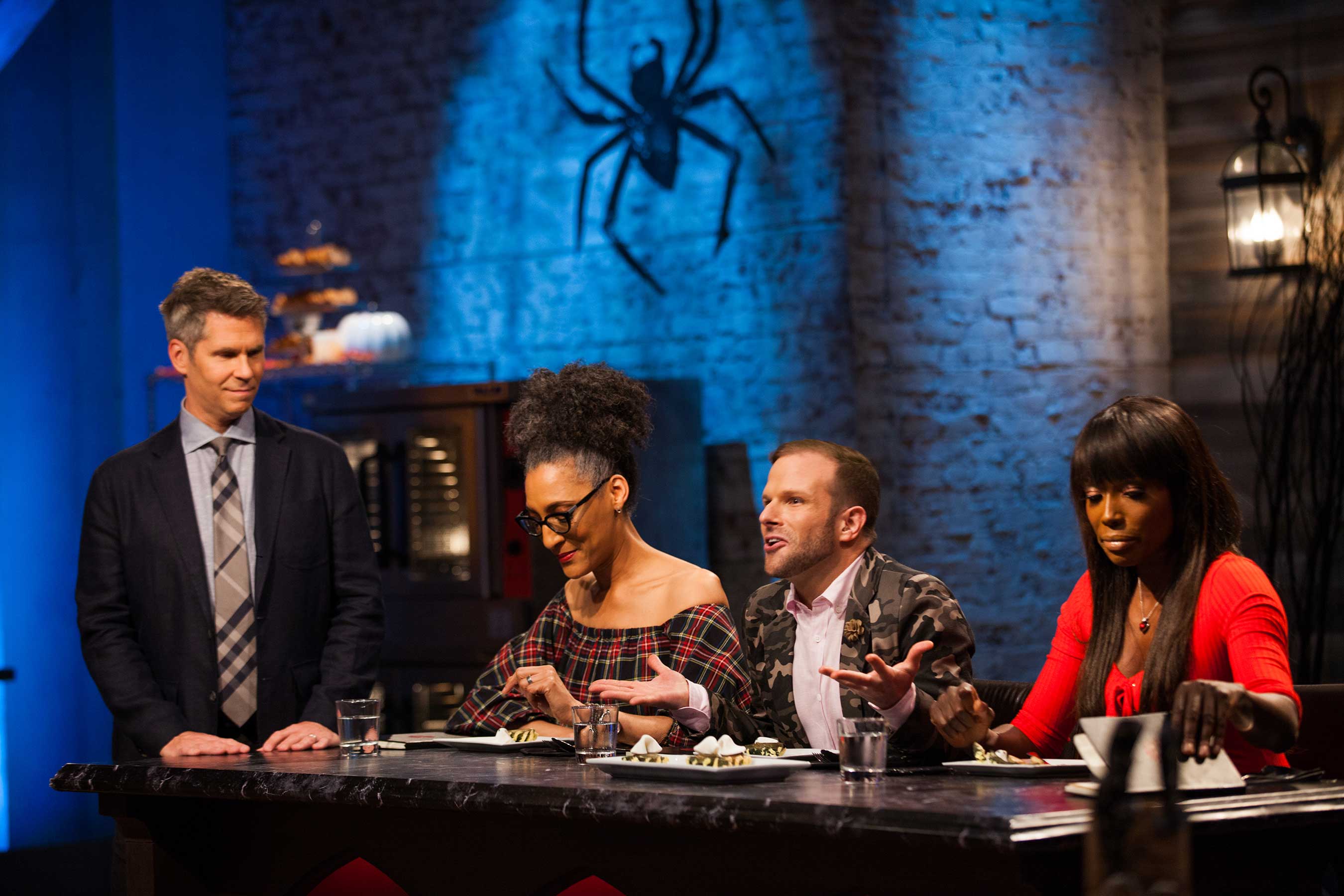 Host John Henson and judges Carla Hall, Zac Young, and Lorraine Pascale on Food Network's Halloween Baking Championship