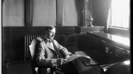 Black and white photograph of Harvey S. Firestone in his study, reading a book
