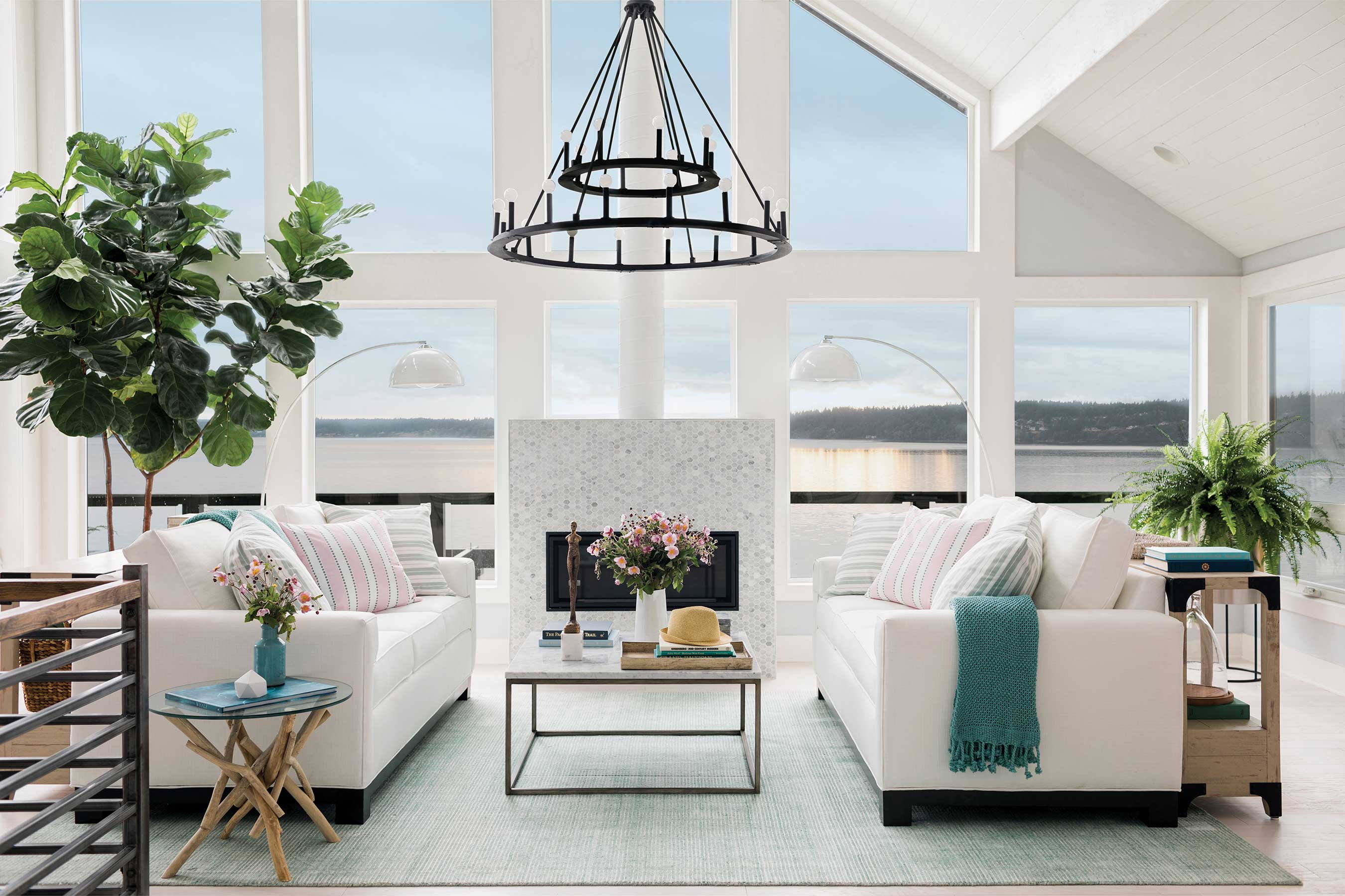 The great room in HGTV Dream Home 2018 makes good use of the incredible scenery, with floor-to-ceiling windows that provide unobstructed views of Puget Sound. Bright white furniture, an industrial iron chandelier, live plants and touches of green and pink reinforce the home’s coastal and traditional style.