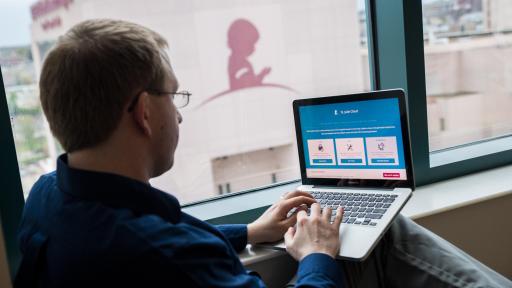 Man using a computer, the screen is showing the new St. Jude cloud interface.