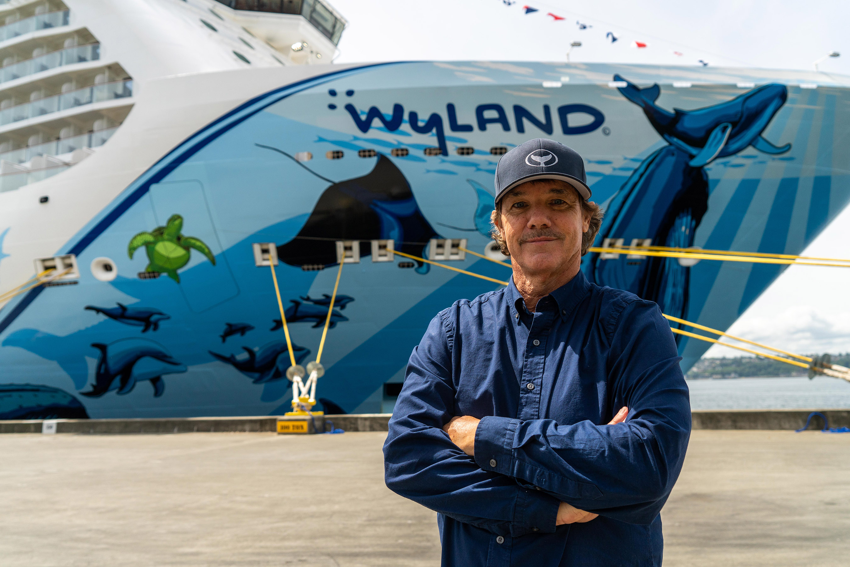 Renowned marine life artist and conservationist, Wyland, in front of his hull art on Norwegian Bliss