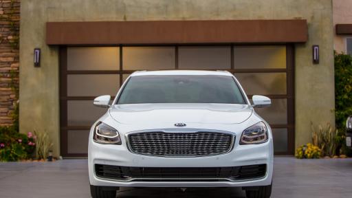 Exterior front end of KIA K900 in front of a garage