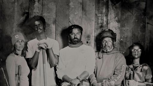 A group picture showing 4 people 2 men and 2 women with gardening tools.