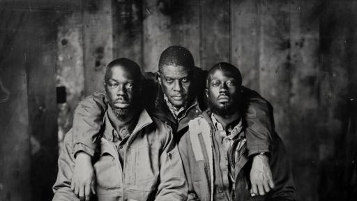 Three men in Carhartt work clothes posing for a photo.