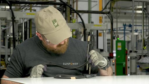 A man solders a cable.
