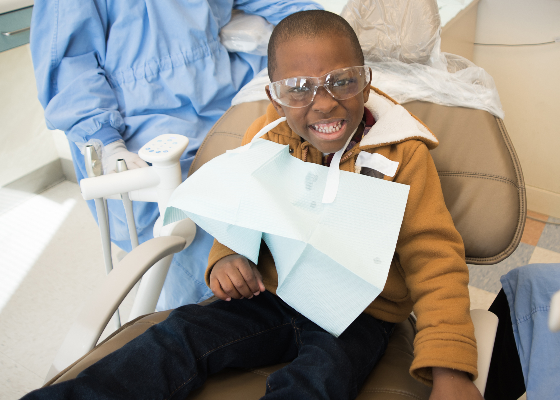 A child shows off his clean teeth after receiving care from a UNC-CH School of Dentistry student.