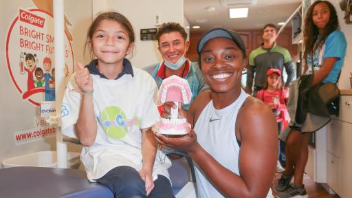 Kid holds model of teeth in the Serving Up Smiles initiative.