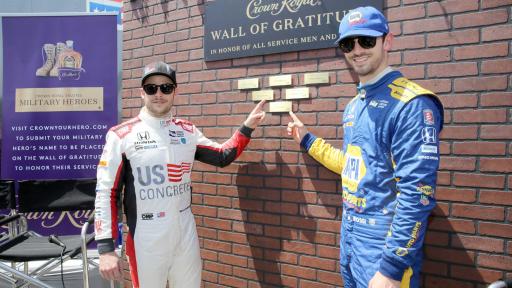 Marco Andretti And Alexander Rossi pointing to plaques on Wall of Gratitude