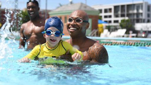 A child is taught to swim by USA Swimming Foundation ambassador and Olympic gold medalist Cullen Jones