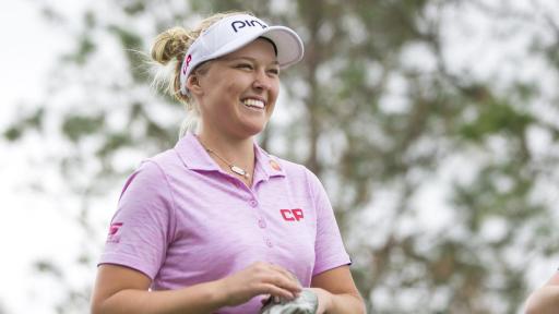 Brooke Henderson smiling and putting on a golf glove